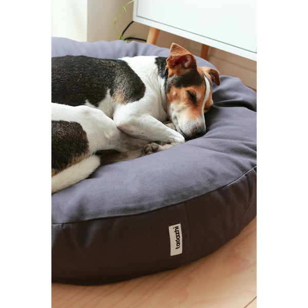 minimalistic round dog cushion with a Danish Swedish farmdog resting on it.